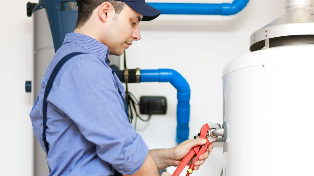 Plumber inspecting a residential water heater to diagnose a hot water problem