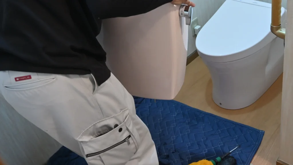 Plumber inspecting a toilet during a base leak repair inspection